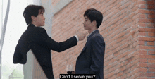 two men in suits are standing next to each other and one of them is asking the other if he can serve him