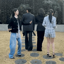 a group of people standing next to each other in front of a brick wall