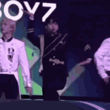 a group of people are standing on a stage in front of a screen that says boyz .