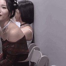 two women are standing next to each other and one is wearing a choker necklace