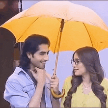 a man and a woman are looking at each other under an umbrella .