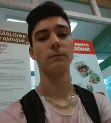 a man is standing in front of a sign that says sarloink e ajanljuk