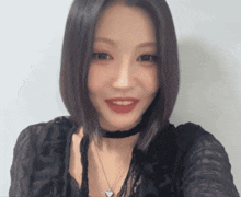 a woman wearing a choker necklace and a black shirt