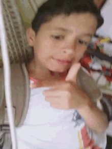 a young boy is giving a thumbs up sign