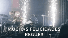 a man playing drums in front of a crowd with the words muchas felicidades regue written below him