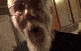 a man with glasses and a beard is making a surprised face