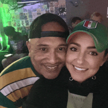 a man and a woman are posing for a picture and the woman is wearing a green hat that says 7 on it