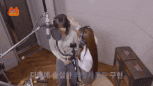 two women wearing headphones in front of a microphone with the word cat on the top left