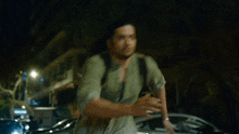 a man with long hair is walking down the street with a backpack .