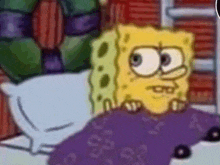 a close up of a cartoon character , spongebob squarepants , laying in a bed .