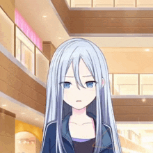 a girl with long white hair and blue eyes is wearing a blue jacket and standing in a mall .