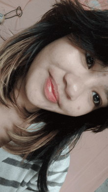 a close up of a woman 's face with a striped shirt