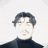 a man with a mustache is wearing a black turtleneck sweater