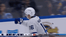 a hockey player wearing a number 16 jersey stands on the ice