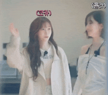 a woman wipes another woman 's face with a towel while they are standing next to each other .