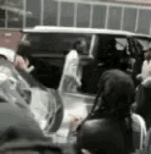 a group of people are standing in front of a car .