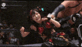 a couple of wrestlers are fighting in a ring with a referee .