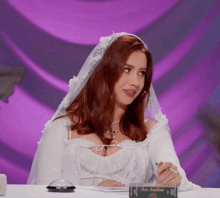 a woman in a bride 's veil is sitting at a table with a book titled ace aaron