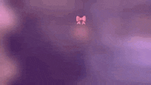a man wearing a pink bow tie is standing in front of a wooden fence .