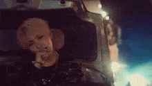 a young man is sitting in the back seat of a car smoking a cigarette .
