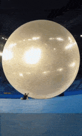a person is sitting under a large white balloon
