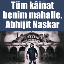 a man is standing in front of a building with the words tüm kainat benim mahalle abhijit naskar