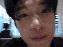 a close up of a young man 's face with a blurry background