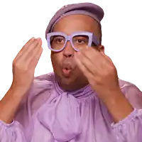 a man wearing glasses and a purple shirt making a funny face