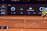 a tennis match is being played in front of a santander advertisement