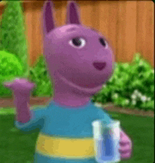 a purple cartoon character is holding a glass of water in his hand .