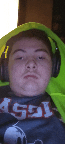 a man wearing headphones and a shirt that says " ash " on it