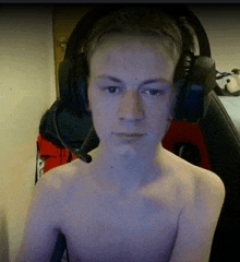 a shirtless man wearing headphones with a microphone