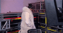 a woman in a fur coat is standing in front of a stack of cases with the numbers stm08037
