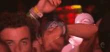 a man with a bandana on his head is dancing in a crowd of people