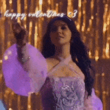 a woman in a purple dress is dancing in front of a gold curtain and giving the middle finger .