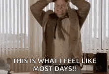a man in a suit and tie is screaming and holding his head in his hands .