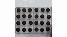 a cooling rack filled with chocolate cookies on a table