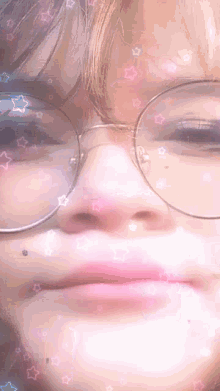 a close up of a person wearing glasses and making a funny face .