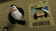 a penguin is standing next to a picture of a man with sunglasses on