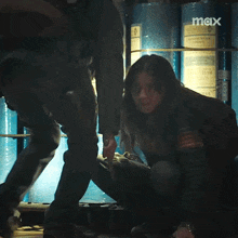 a woman is being held by a man in a dark room with the word max on the bottom right