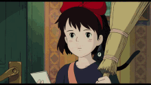 a girl with a red bow on her head is holding a broom and a piece of paper