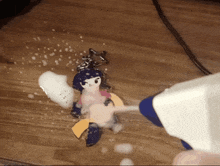a person spraying foam on a keychain on a table