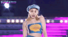 a woman is standing on a stage wearing a blue hat and a blue top .