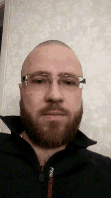 a man with a beard wearing glasses and a black shirt that says peak performance