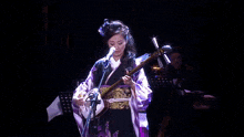 a person is playing a musical instrument with a microphone in the background