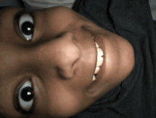 a close up of a person 's face with a big smile