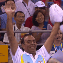 a man wearing a shirt that says cag holds his hand up in the air