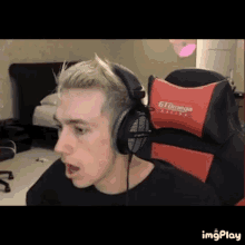 a man wearing headphones is sitting in a gaming chair .