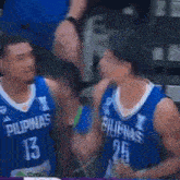 a couple of basketball players are standing next to each other .