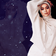 a woman wearing a hijab and a white sweater stands in front of a dark background